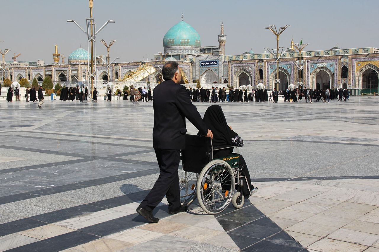 خادمان صندلی‌ چرخدار حرم مطهر رضوی آماده خدمت به زائران پیاده